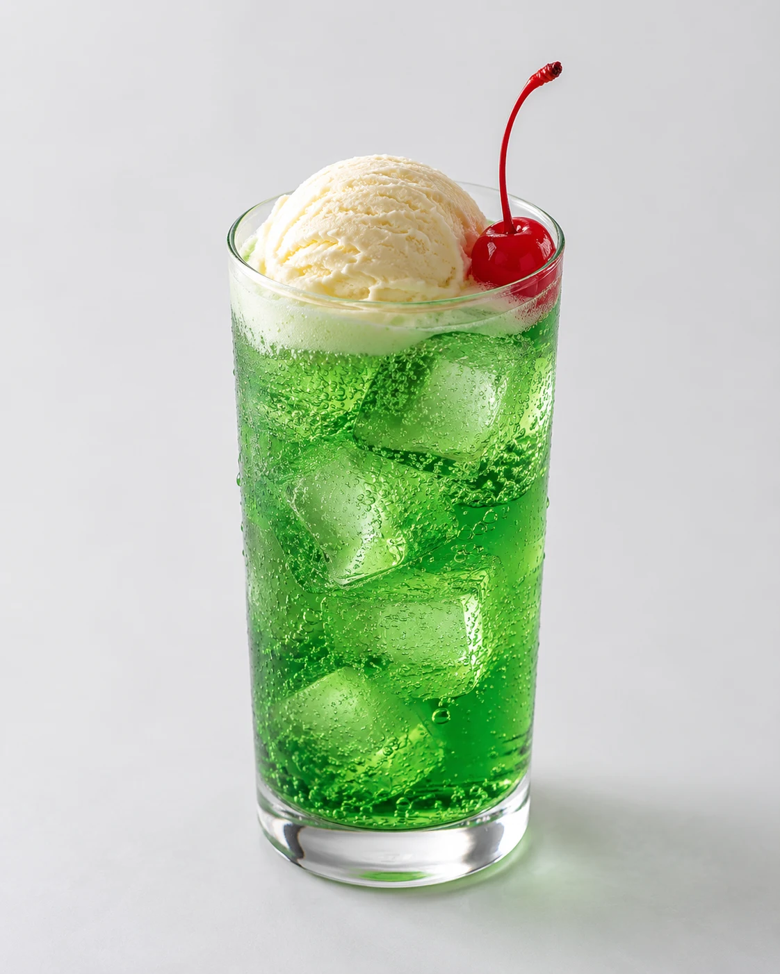 さくらんぼを添えた緑色のクリームソーダ
